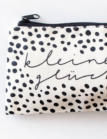 Bawełniana kosmetyczka z sitodrukiem w formie czarnych kropek.